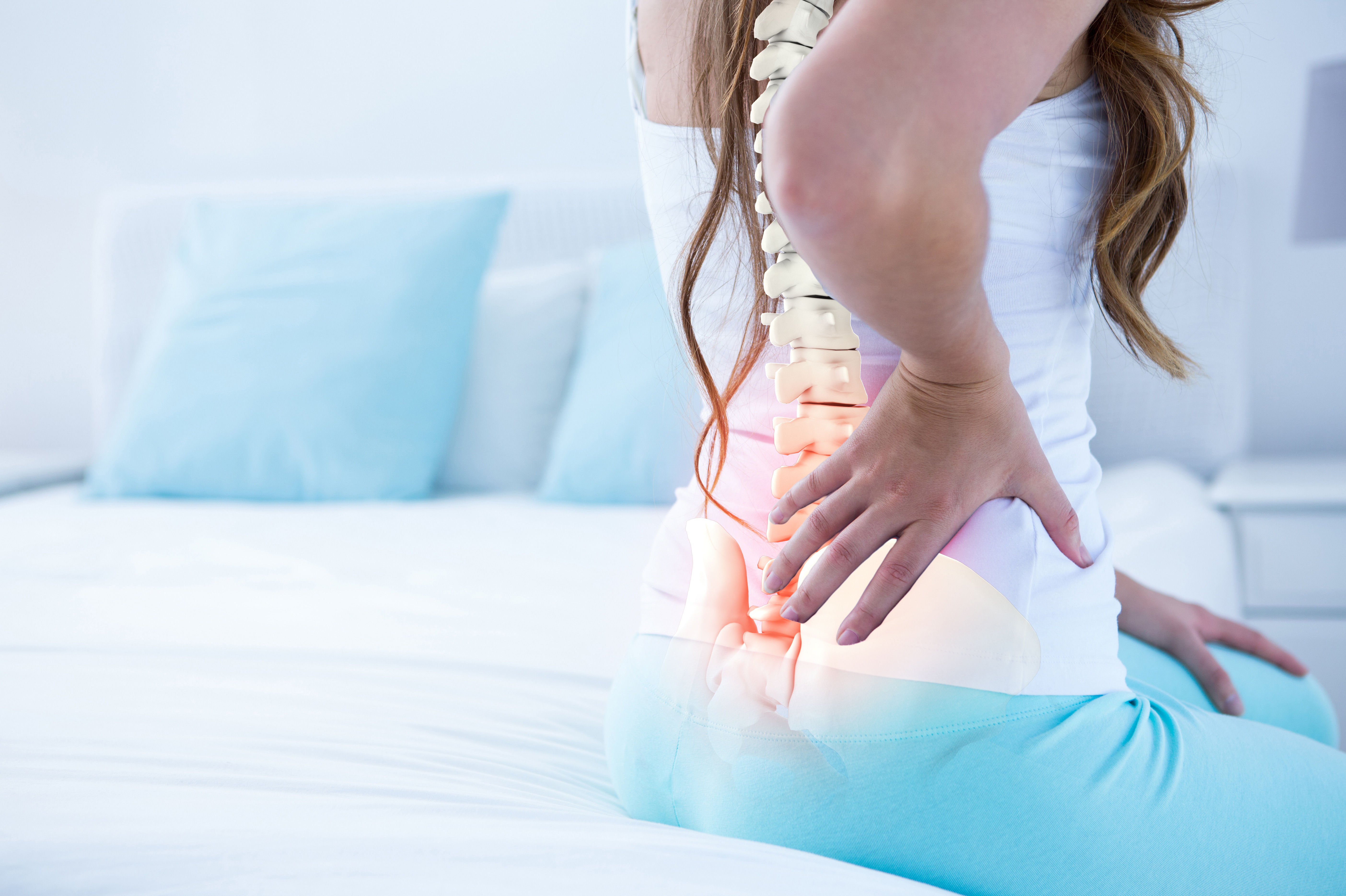 The image shows a person sitting on a bed, holding their lower back in pain, with a visual representation of the spine and affected area highlighted.