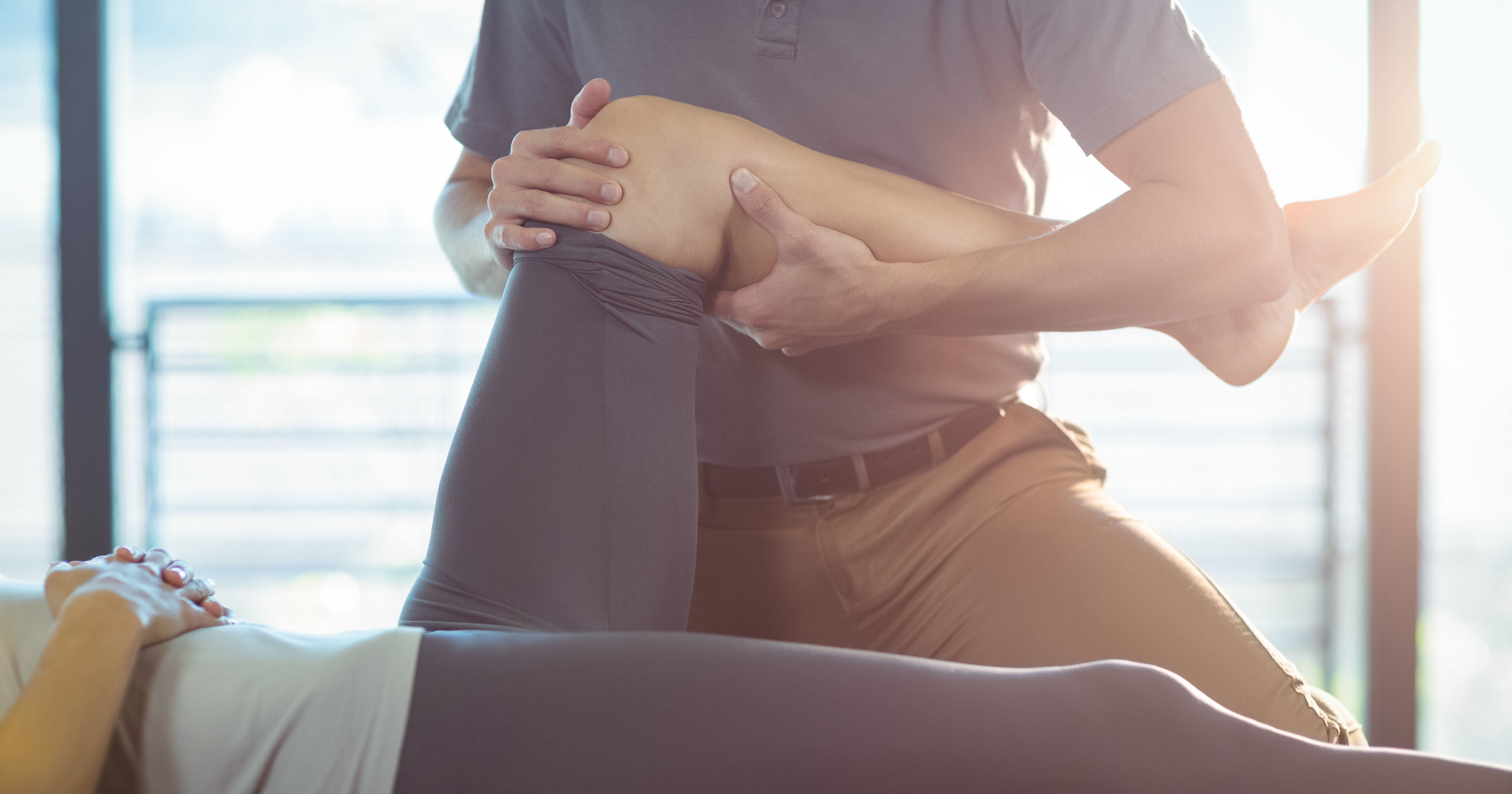 Physiotherapist giving knee therapy to a woman