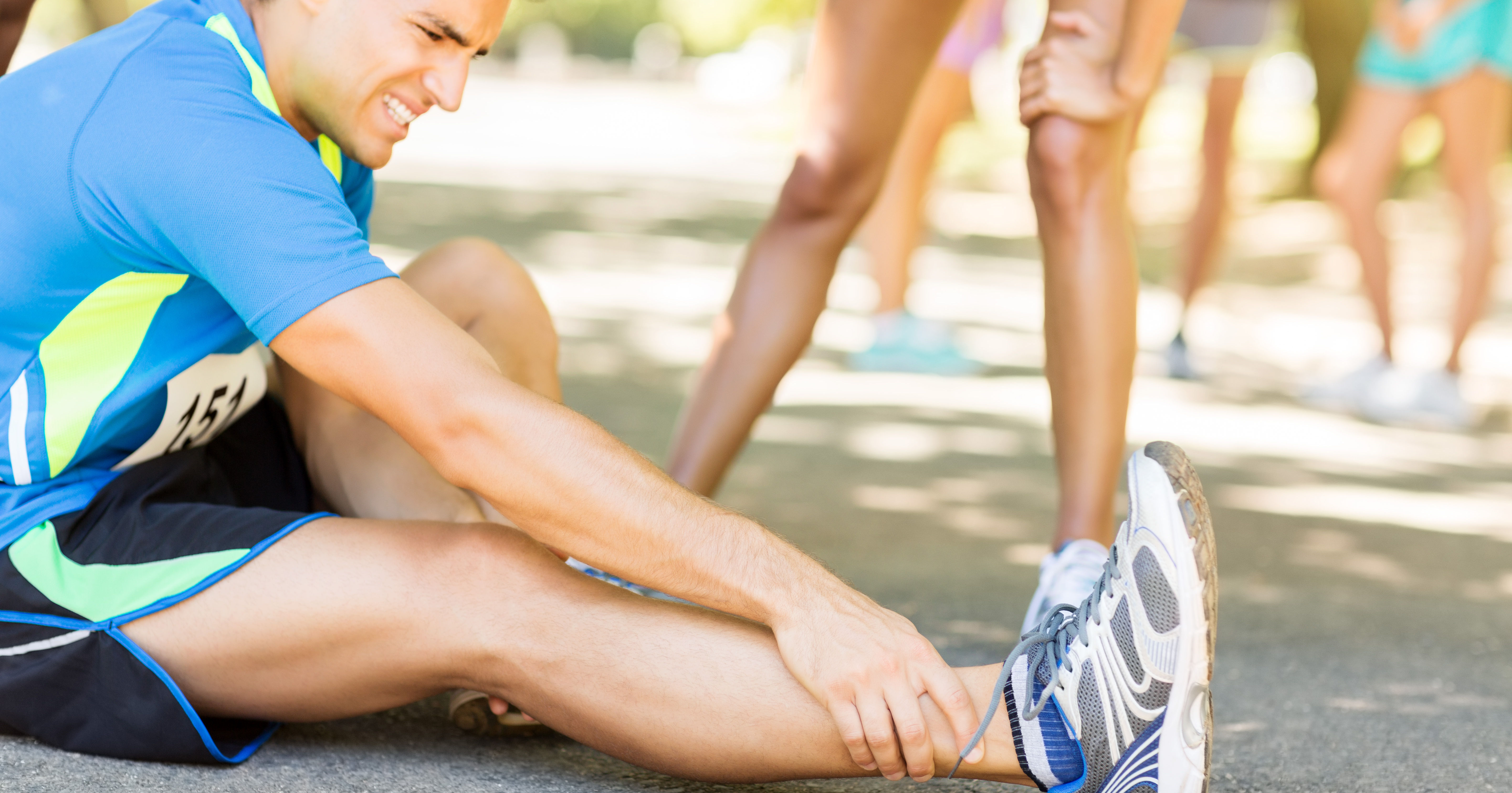 Man Suffering From Ankle Pain On Street During Mar