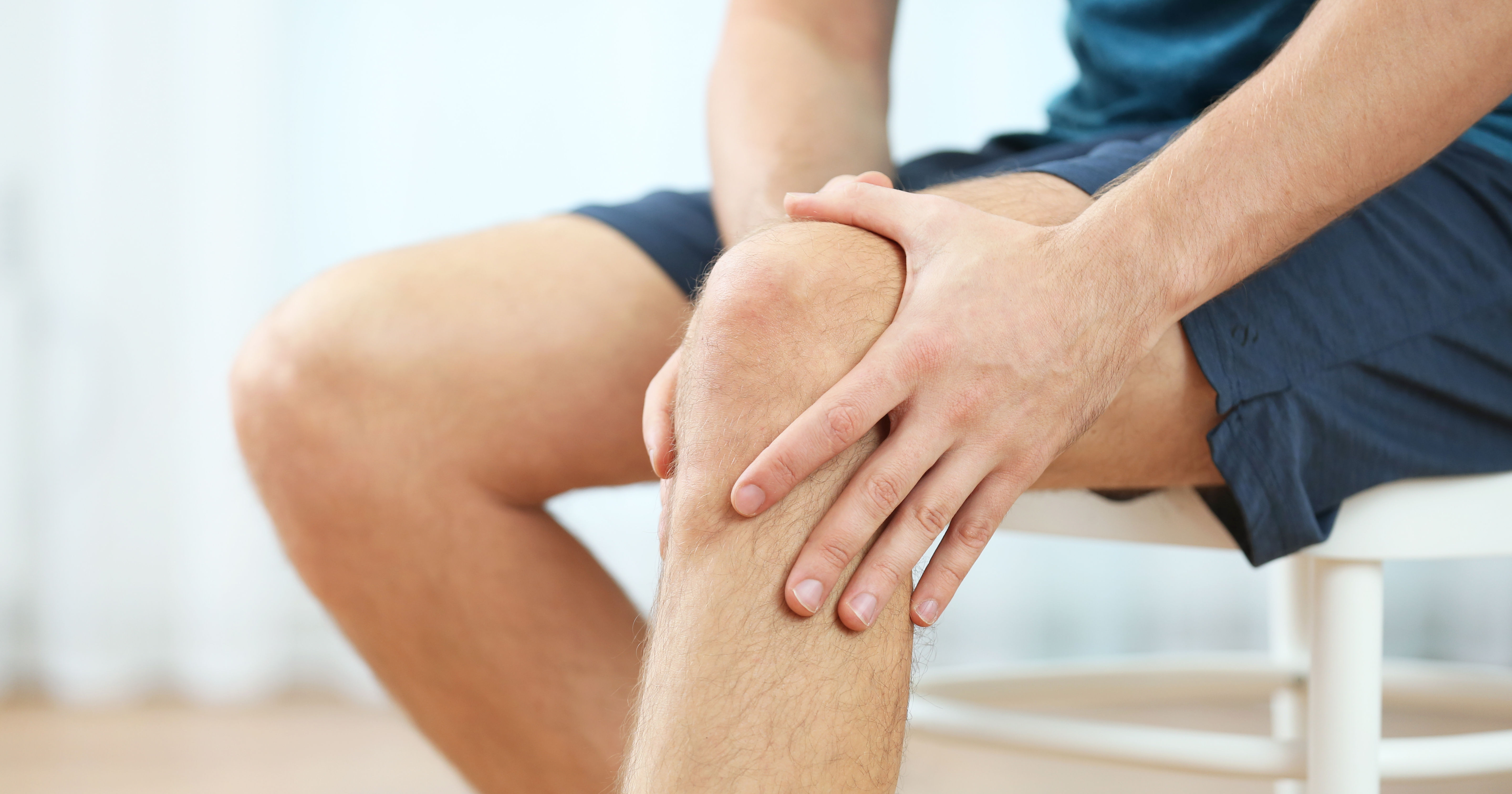  Young man holding knee