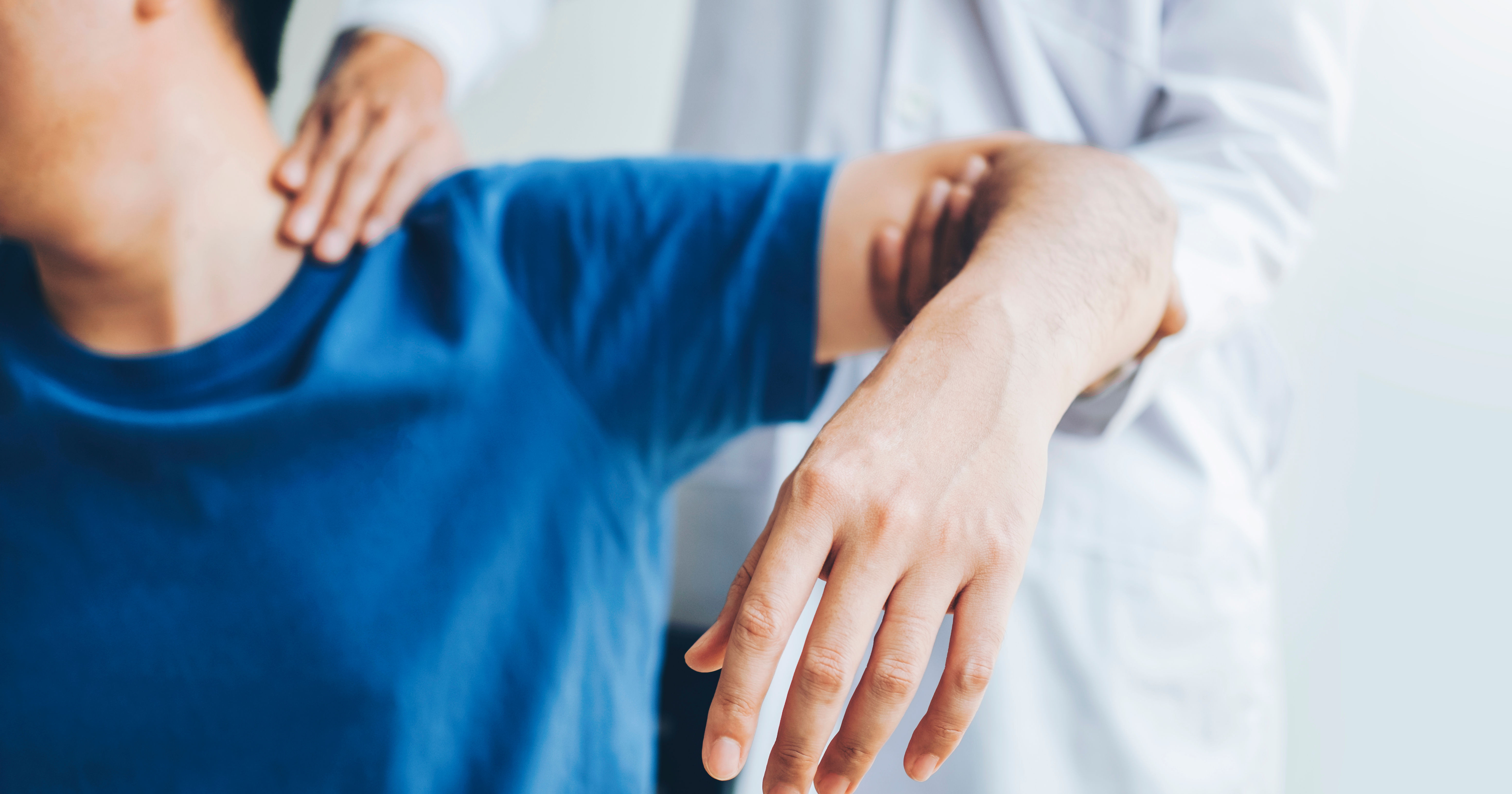 Doctor consulting with patient about shoulder pain