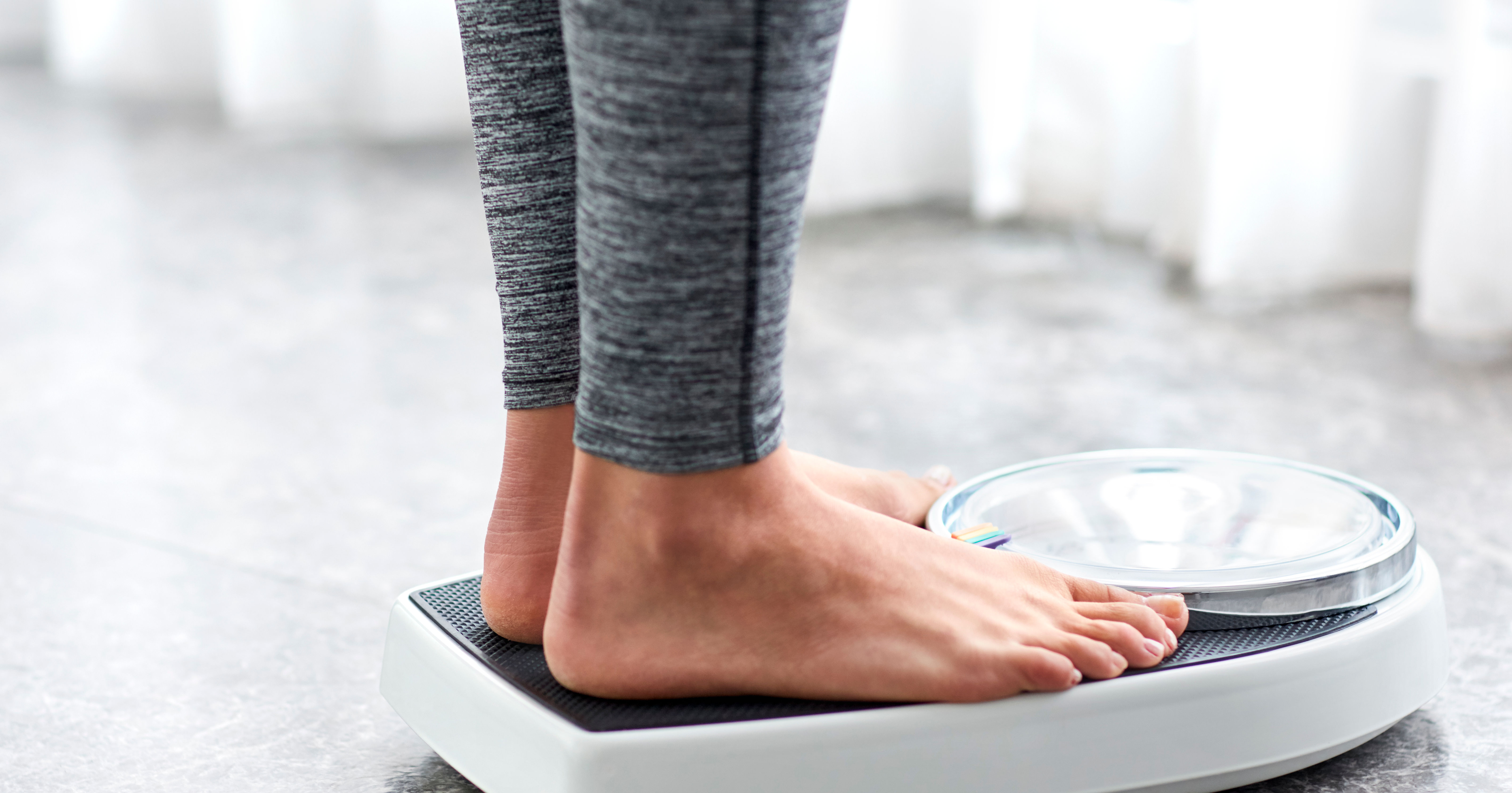 Young healthy girl on home scales
