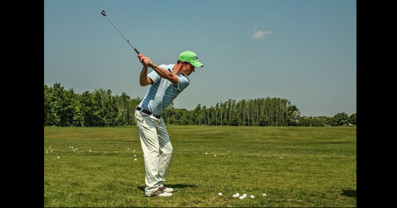 man in a green hat an off white pants practicing summer sports safety while golfing