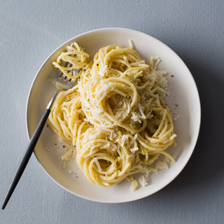 white cacio e pepe pasta in a bowl with a black and silver fork