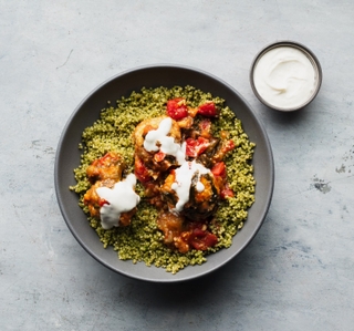 grey round bowl with cilantro quinoa and three ground chicken meatballs with tomatillo sauce and cumin yogurt on top