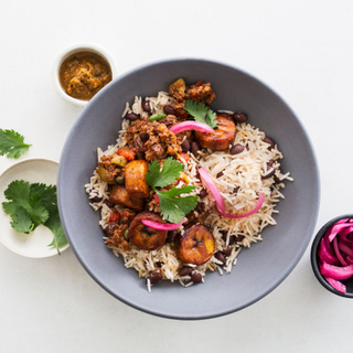 black bowl with cuban-style beef, black beans and rice with pickled red onions and fresh cilantro