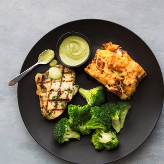 grilled swordfish steak on a bed of steamed spaghetti squash with tomato and olive relish