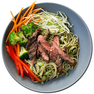 Blue bowl with peppered steak and noodle salad with broccoli florets, thinly sliced red bell peppers, green cabbage and carrots. 