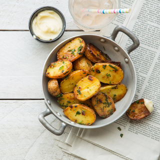 dish of garlic and parsley roasted potatoes with mayonnaise sauce on the side