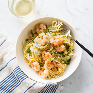 white bowl with shrimp scampi on a marble background