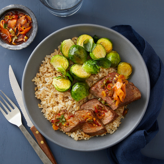 steak brown rice bowl with steamed brussels sprouts and ginger-soy dressing