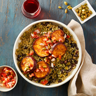 Yam and quinoa bowl with sliced roasted sweet potatoes on a blue wooden background