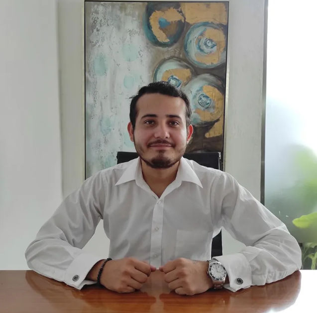 Contacto Experto Inmobiliario Gran Provincia | Itzimna Real Estate Retrato profesional de un asesor y abogado inmobiliario de Itzimna Real Estate vistiendo camisa blanca en su escritorio, especialista en la venta de lotes para el desarrollo Gran Provincia en Yucatán.
