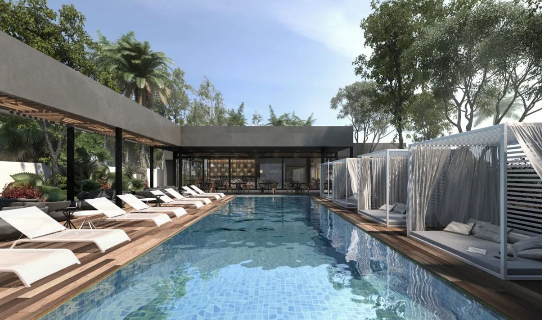 Premium Amenities: Pool and Clubhouse at Silvesta Residencial Merida | Itzimna Real Estate Main pool and swimming channel with wooden sundecks and private cabanas at the Silvesta Residencial Clubhouse in Merida, surrounded by nature.