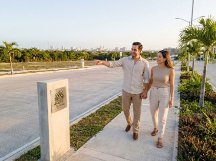 Desarrollo de lotes semiurbanizados en Mérida de alta plusvalía - Itzimna Real Estate Pareja evaluando lotes semiurbanizados Mérida alta plusvalía en desarrollo de Itzimna Real Estate