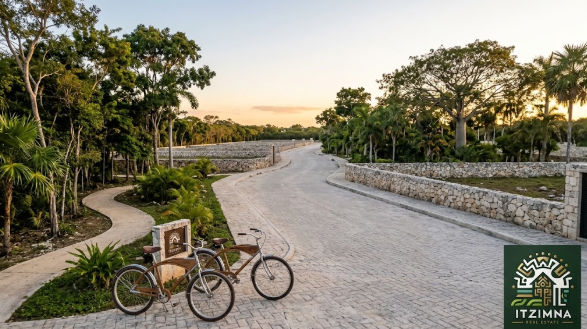Terrenos Campestres Mérida Inversión Segura - Itzimna Real Estate Camino pavimentado con bicicletas y áreas verdes en desarrollo de terrenos campestres Mérida inversión