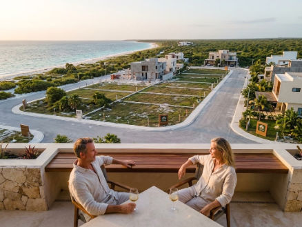 Desarrollo residencial premium de terrenos cerca de la playa Yucatán 2027 con Itzimná Real Estate Pareja de inversionistas en terraza observando lotes urbanizados y terrenos cerca de la playa Yucatán 2027
