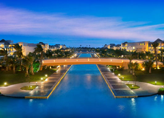 Illuminated bridge over central pool at Hard Rock Hotel and Casino Punta Cana at twilight