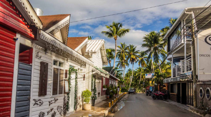 Calle tropical pintoresca con coloridas casas de madera tradicionales y altas palmeras