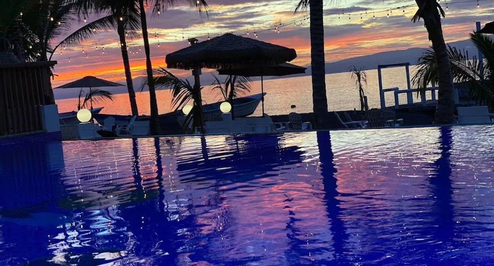 Pool area at Sun on the bay beach hotel featuring modern lounge chairs and contemporary architecture under a cloudy sky