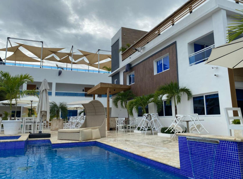 Pool area at Sun on the bay beach hotel featuring modern lounge chairs and contemporary architecture under a cloudy sky