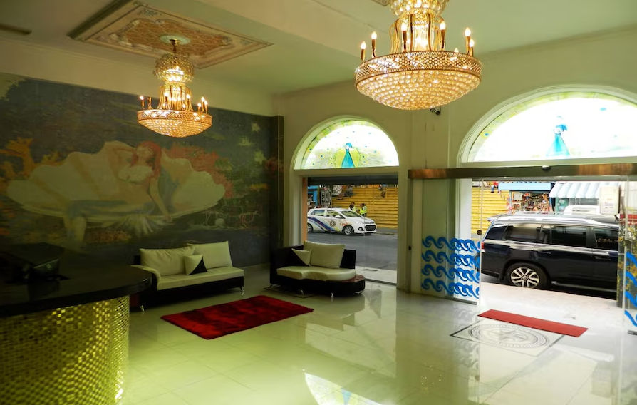Circular indoor pool or jacuzzi inside the spa area at Hotel Spa Bella Mar, surrounded by classical white columns, blue tiled steps, and wavy patterned flooring.