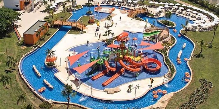 Vista aérea de un resort familiar con río lento y toboganes de agua