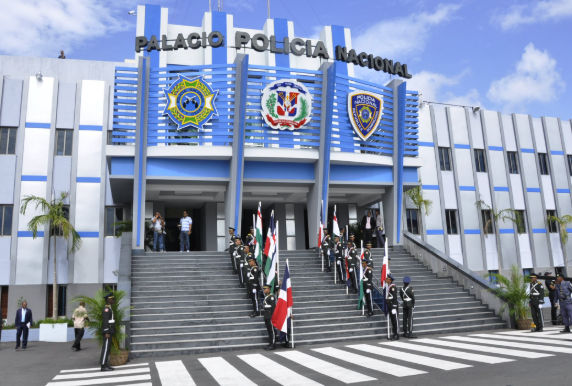Dominican Republic National Police headquarters building with officers holding flags on the front steps