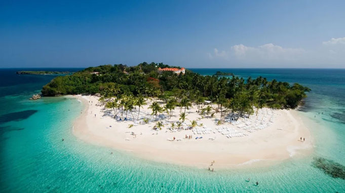 Aerial view of a beautiful tropical island with a white sand beach, palm trees, and clear turquoise water