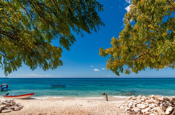 Scenic view of a beautiful beach with clear turquoise water and small boats in Bahia de las Aguilas