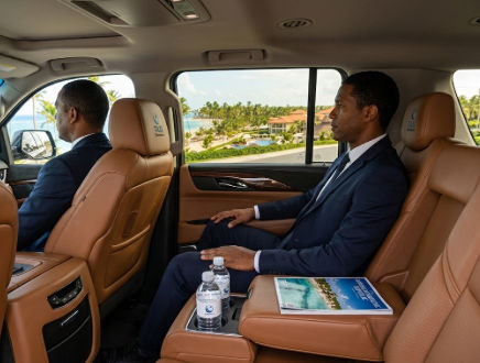 Passenger relaxing inside a luxury SUV transfer in Punta Cana with tan leather seats and a professional chauffeur