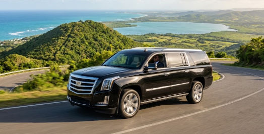 Luxury SUV private transfer in motion near Montaña Redonda with sea views
