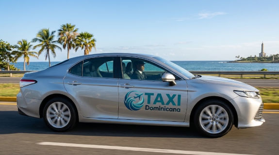 Taxi Dominicana: Sedán plateado de transporte privado conduciendo por la carretera costera de Santo Domingo Este, con palmeras y mar