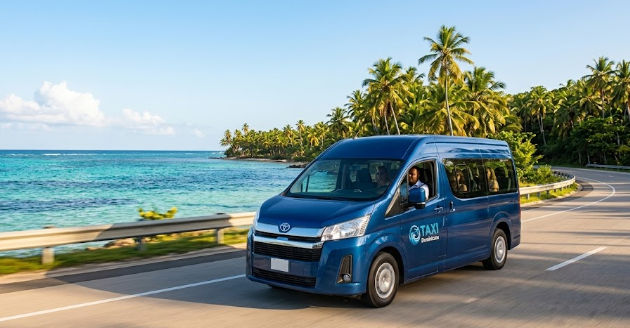 A blue Toyota Granvia 'TAXI Dominicana' van driving on a coastal road for a Saona Island holiday excursion