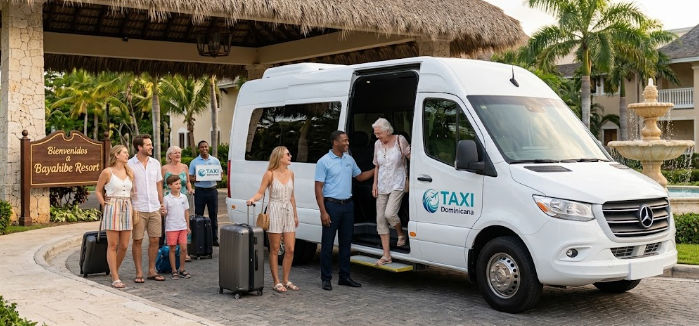 Grupo de turistas con maletas bajando de un van de transporte turístico con el logo de Taxi Dominicana frente a la entrada del Bayahibe Resort