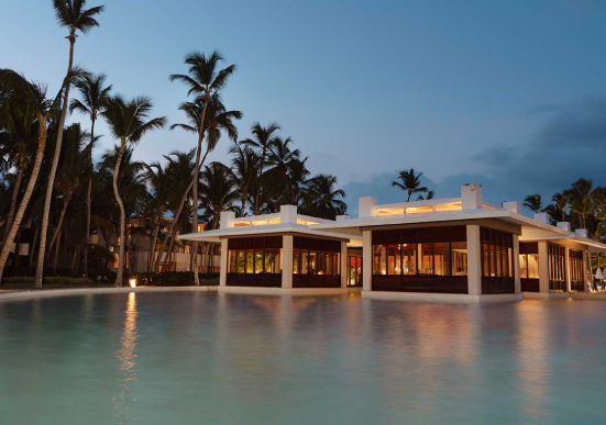 Vista nocturna de la piscina y las instalaciones del resort Catalonia Royal Bavaro