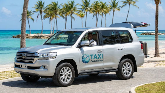 Luxury silver SUV from Taxi Dominicana providing private transfer service on a tropical beach