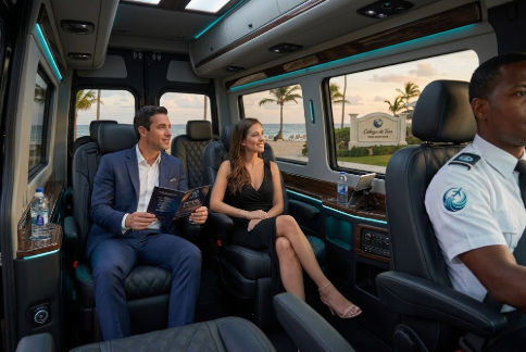 Pareja elegante disfrutando del interior de un transporte privado de lujo hacia Pearl Beach Club