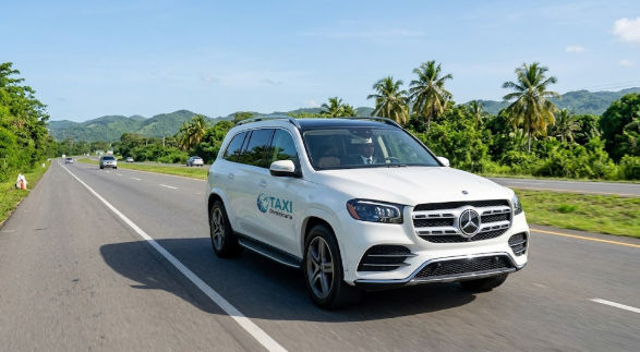 Vehículo SUV blanco de lujo realizando transporte privado en carretera tropical
