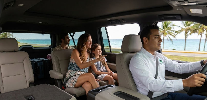 Taxi Shuttle Cancun: Servicio de transporte privado premium desde el aeropuerto a la Zona Hotelera y Riviera Maya Interior de una Suburban de Taxi Shuttle Cancun con familia viajando c贸modamente por la costa del Caribe Mexicano hacia su hotel