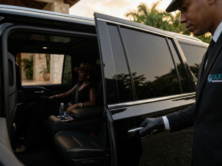 A professional chauffeur in a uniform opens the door of a black luxury SUV for a VIP passenger in the Dominican Republic.