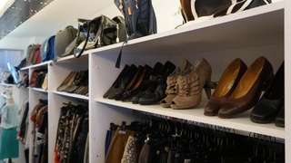 Sue Ryder secondhand clothing women men store Bruges COSH interior shoes
