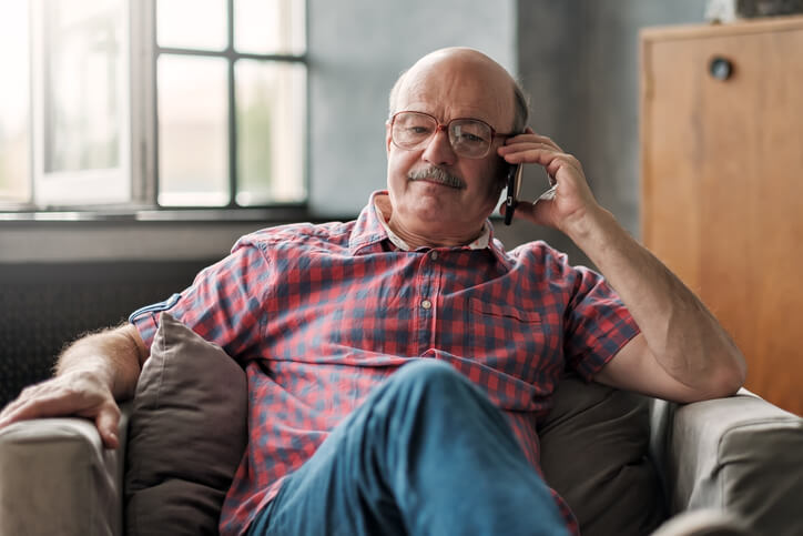 Elder man on sofa chair on the phone with his DailyDoctor physician.