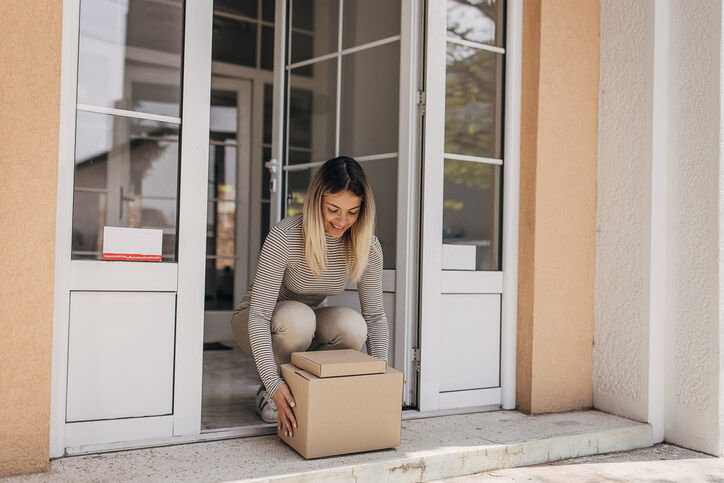 Women getting DailyDoctor health kit package at door.