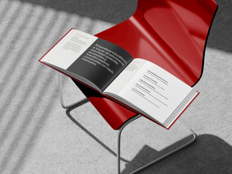 Brand manual mockup on red chair featuring minimalist layout and professional sans-serif typography.