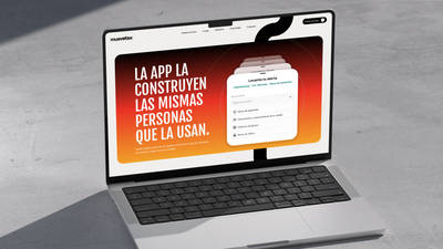 A laptop displaying the Muevetex website hero section, reading "La app la construyen las mismas personas que la usan" beside a red-to-orange gradient panel showing the in-app alert flow "Levanta tu alerta."