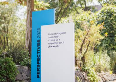 Layered outdoor signage totem with clean typography reading "Hay una pregunta que ningún modelo va a responder por ti: ¿Para qué?"