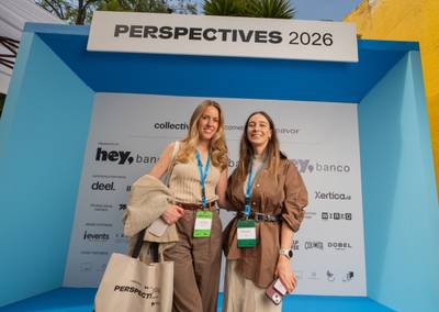 Event participants posing at the 3D blue photo booth backdrop showcasing partner logos.