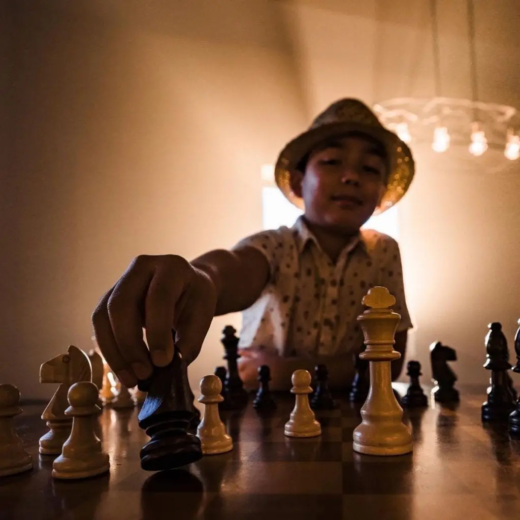 kid plays chess in foggy room