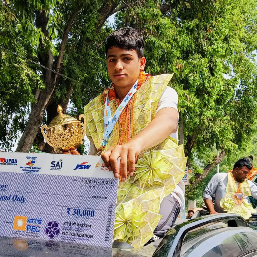 Two young boxers and officials in the ring after a match.
